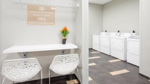 a white kitchen with white sinks and white stools at Candlewood Suites Kearney, an IHG Hotel in Kearney