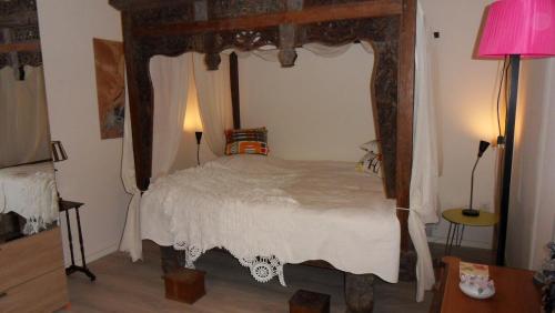 a bedroom with a canopy bed and a pink lamp at Ambiance in Zierikzee