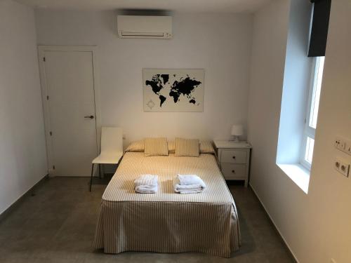 a bedroom with a bed with two towels on it at Apartamento Gran Teatro Falla-La Caleta in Cádiz