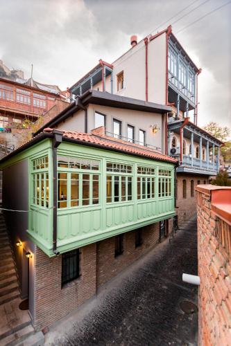 a building with a green facade on a street at Boutique Apart Upe in Tbilisi City