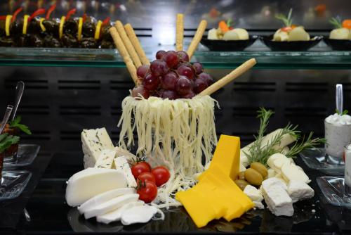 Una exhibición de quesos y otros alimentos en una mesa. en Rotta Hotel Istanbul, en Estambul