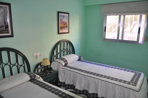 duas camas num quarto com paredes verdes em BENIDORM LEVANTE BEACH VIEWS em Benidorm