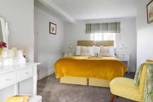une chambre avec un grand lit avec une couverture jaune dans l'établissement Carr Cottage, à Leeds