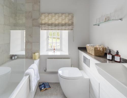 une salle de bains blanche avec toilettes et lavabo dans l'établissement Carr Cottage, à Leeds