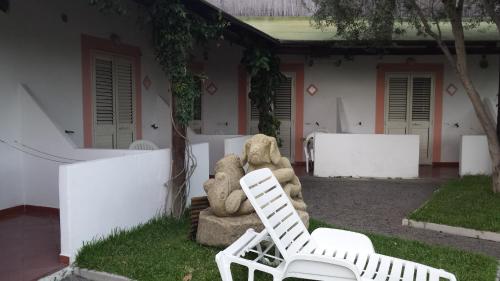 two white chairs sitting in front of a house at Hotel Castiglione in Ischia