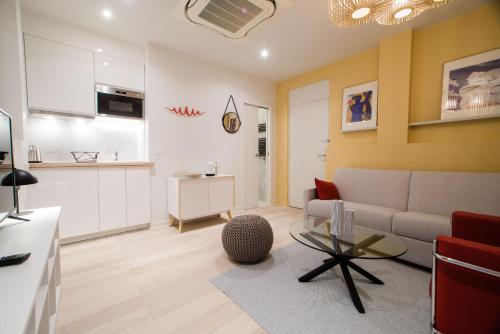 un salon avec un canapé et une table dans l'établissement SUITE ELUARD au cœur de la Rive Gauche, neuf, design, 2-4 personnes, à Paris