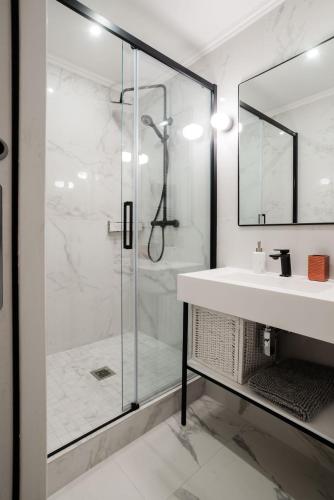 une salle de bain avec une douche en verre et un lavabo dans l'établissement SUITE ELUARD au cœur de la Rive Gauche, neuf, design, 2-4 personnes, à Paris