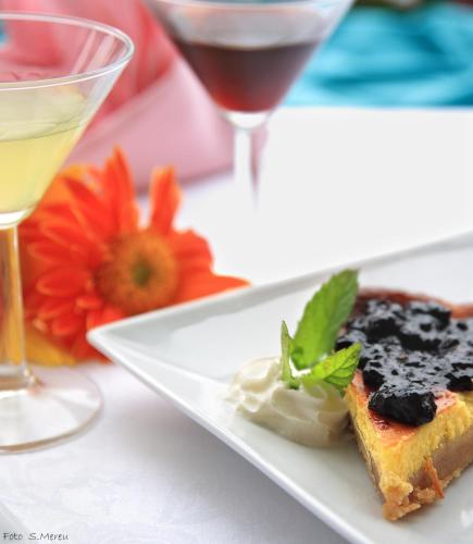 a white plate with a piece of food and a glass of wine at Hotel Pop in Cala Gonone