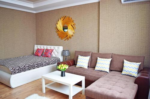 a living room with a couch and a mirror at Bishkek Sunny Apartment in the center in Bishkek