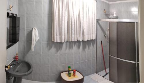 a small bathroom with a sink and a shower at Casa Gomes in Praia Grande