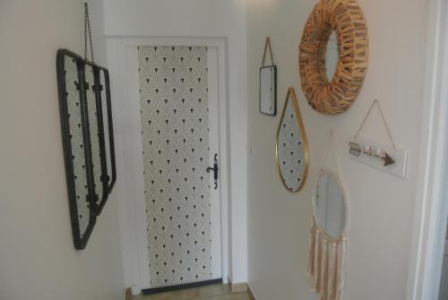 un couloir avec une porte et des horloges sur le mur dans l'établissement Le Temps Retrouvé, à Saint-Martin-de-Valgalgues