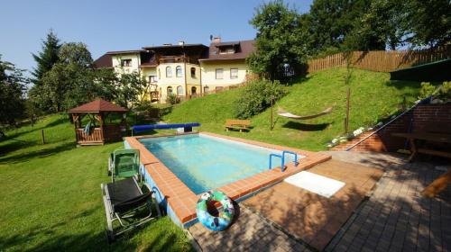 een zwembad in een tuin naast een huis bij Agroturystyka U Matysa Wisła in Wisła
