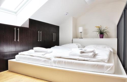 1 dormitorio con 1 cama grande con sábanas blancas en Pálavské Vinohrady, en Pavlov