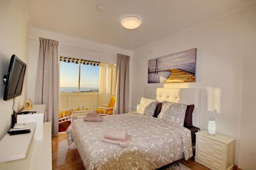 a white bedroom with a bed and a window at Cozy Townhouse With Ocean Views in Costa Adeje in Adeje