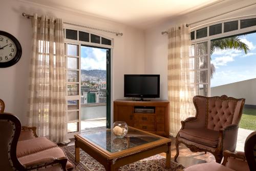 a living room with a tv and a large window at Gem of a House by Homie in Funchal