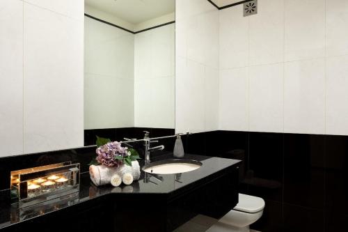 a bathroom with a sink and a toilet and a fireplace at Gem of a House by Homie in Funchal