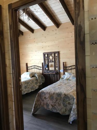 um quarto com 2 camas num chalé de madeira em Casa rural Vega alta em Madridejos