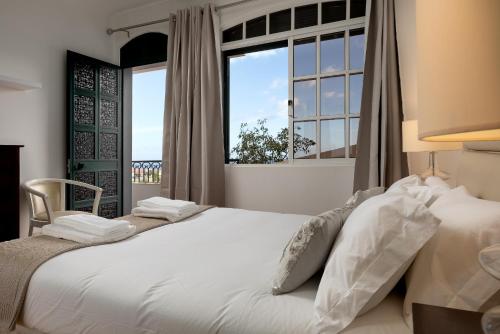 a bedroom with a large white bed with a window at Gem of a House by Homie in Funchal