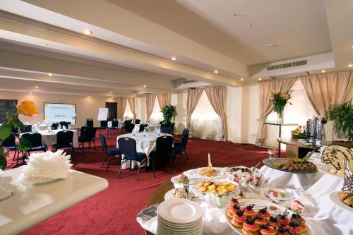 a room with tables and chairs with food on them at Dome Marina Hotel & Resort Ain Sokhna in Ain Sokhna