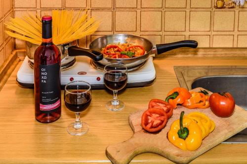 a table with two glasses of wine and a pot of pasta at Louladakis Apartments in Kolymvari