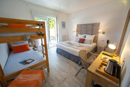 a small room with two bunk beds and a desk at Hôtel Le Vert Bois in Dolus-d'Oléron