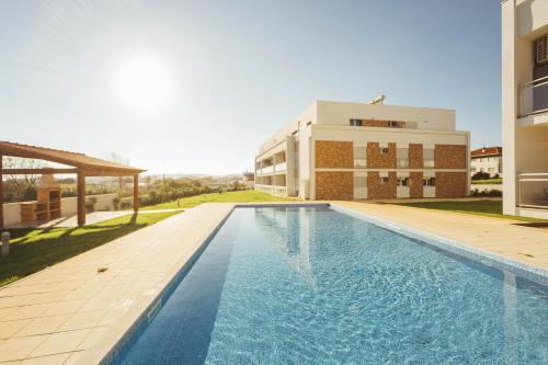 a swimming pool in front of a building at Carmona - By SCH in São Martinho do Porto