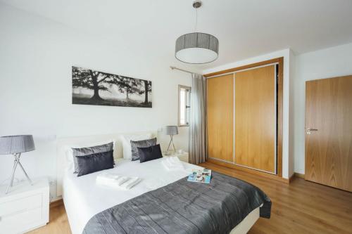 a bedroom with a large bed and a wooden door at Dunas - Holiday Apartments - By SCH in Salir de Porto