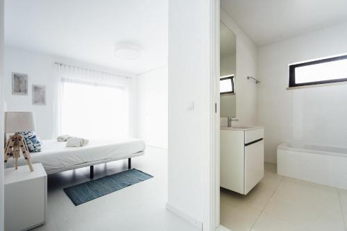een witte badkamer met een bed, een bad en een wastafel bij Janelas de Salir - By SCH in Salir de Porto