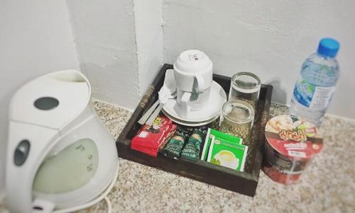a bathroom counter with a coffee maker and a toilet at บ้านพระจันทร์ รีสอร์ท in Ban Khok Sawang (1)