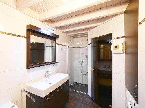 a bathroom with a sink and a mirror and a shower at Ferienhaus Ostseeblick 236 in Baabe
