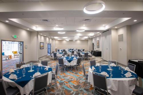 a banquet hall with blue tables and chairs at Holiday Inn Pensacola - University Area by IHG in Pensacola