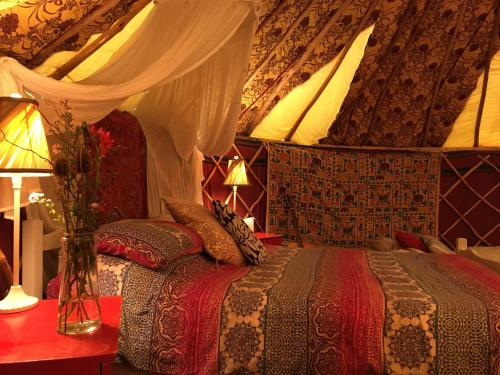 a bedroom with a bed with a canopy at Inch Hideaway Eco Camping in Whitegate