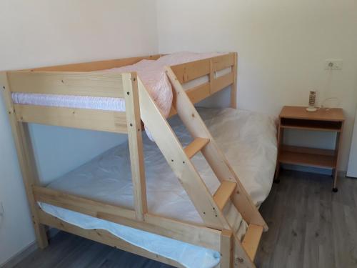drewnianym łóżkiem piętrowym z drabiną w pokoju w obiekcie Sorily w Koprze