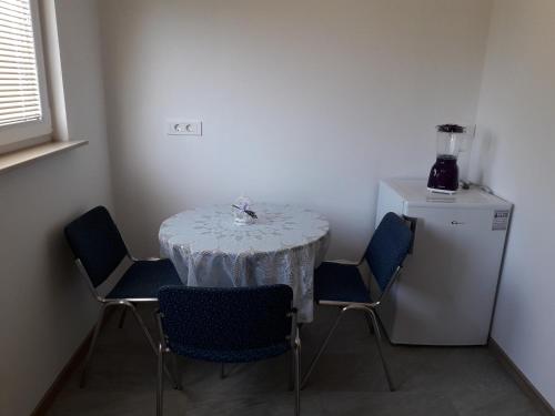 stół jadalny z krzesłami i mała lodówka w obiekcie Sorily w Koprze