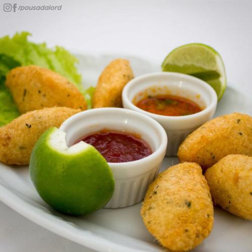 a plate of food with dipping sauce and an apple at Hotel Pousada Lord in Teixeira de Freitas