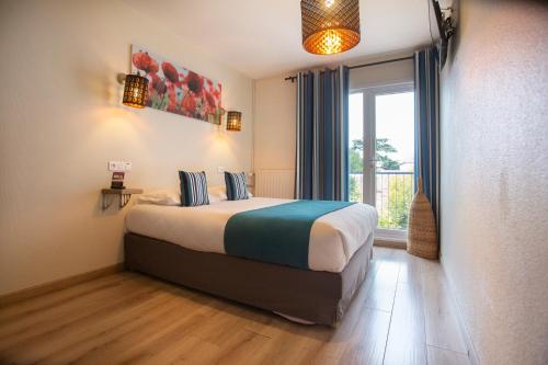 a hotel room with a bed and a window at Hotel Epi d'Or in Angoulême