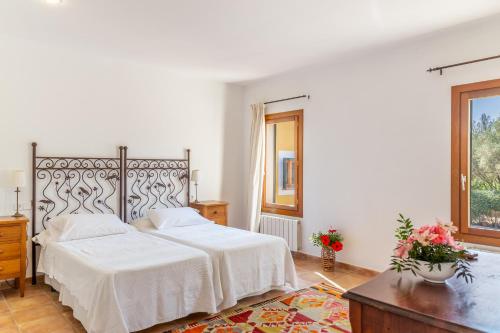 a white bedroom with a bed and a table at Finca Son Blat in Porto Cristo