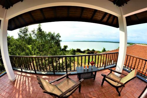 a balcony with a table and chairs and a view of the water at Ashansa Lagoon Resort in Tangalle