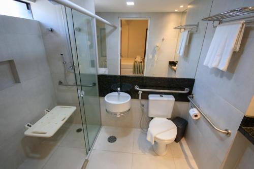 a bathroom with a toilet and a sink and a shower at Tambaqui Praia Hotel in Maceió