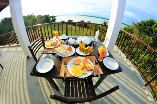a table with plates of food on a balcony at Ashansa Lagoon Resort in Tangalle