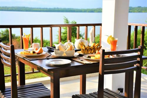 a table with plates of food on a balcony at Ashansa Lagoon Resort in Tangalle