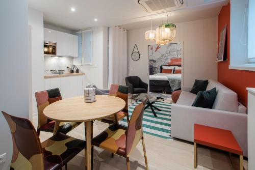 une cuisine et un salon avec une table et des chaises dans l'établissement SUITE SARTRE : au cœur de la Rive Gauche, neuf, design, 2/4 personnes, à Paris