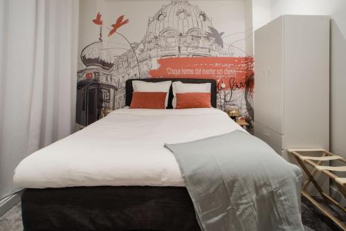 une chambre avec un grand lit blanc avec des oreillers rouges dans l'établissement SUITE SARTRE : au cœur de la Rive Gauche, neuf, design, 2/4 personnes, à Paris