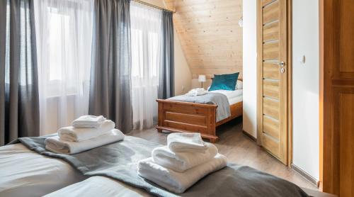 a room with two beds with towels on them at Willa Goszczyńskiego in Zakopane