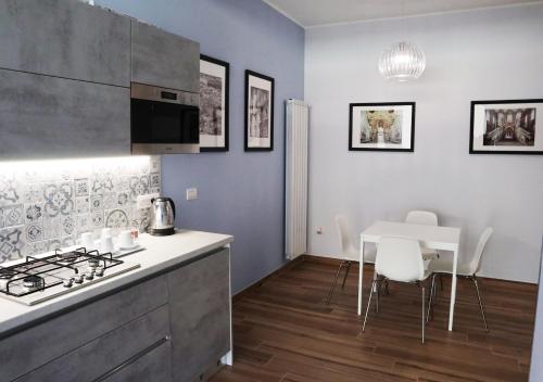 a kitchen with a stove and a table with chairs at Residenza La Reggia in Caserta