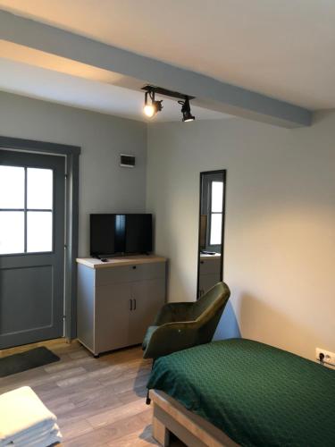 a bedroom with a bed and a tv and a couch at Robert Local Social Restaurant & Accomodation in Hîrşova