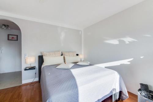 Ferienwohnung Seebruck في زيبرُك: غرفة نوم بيضاء مع سرير مع وسادتين