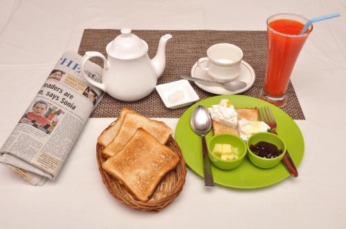 a table with a plate of toast and a newspaper at Hotel Ramakrishna in Mahabalipuram