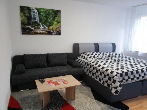 uma sala de estar com um sofá e uma cama em KM Apartment em Triberg