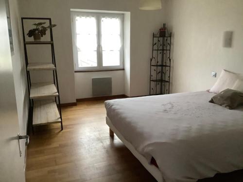 um quarto com uma cama branca e uma janela em Belge ' Attitude Gîte 2 chambres em Commequiers